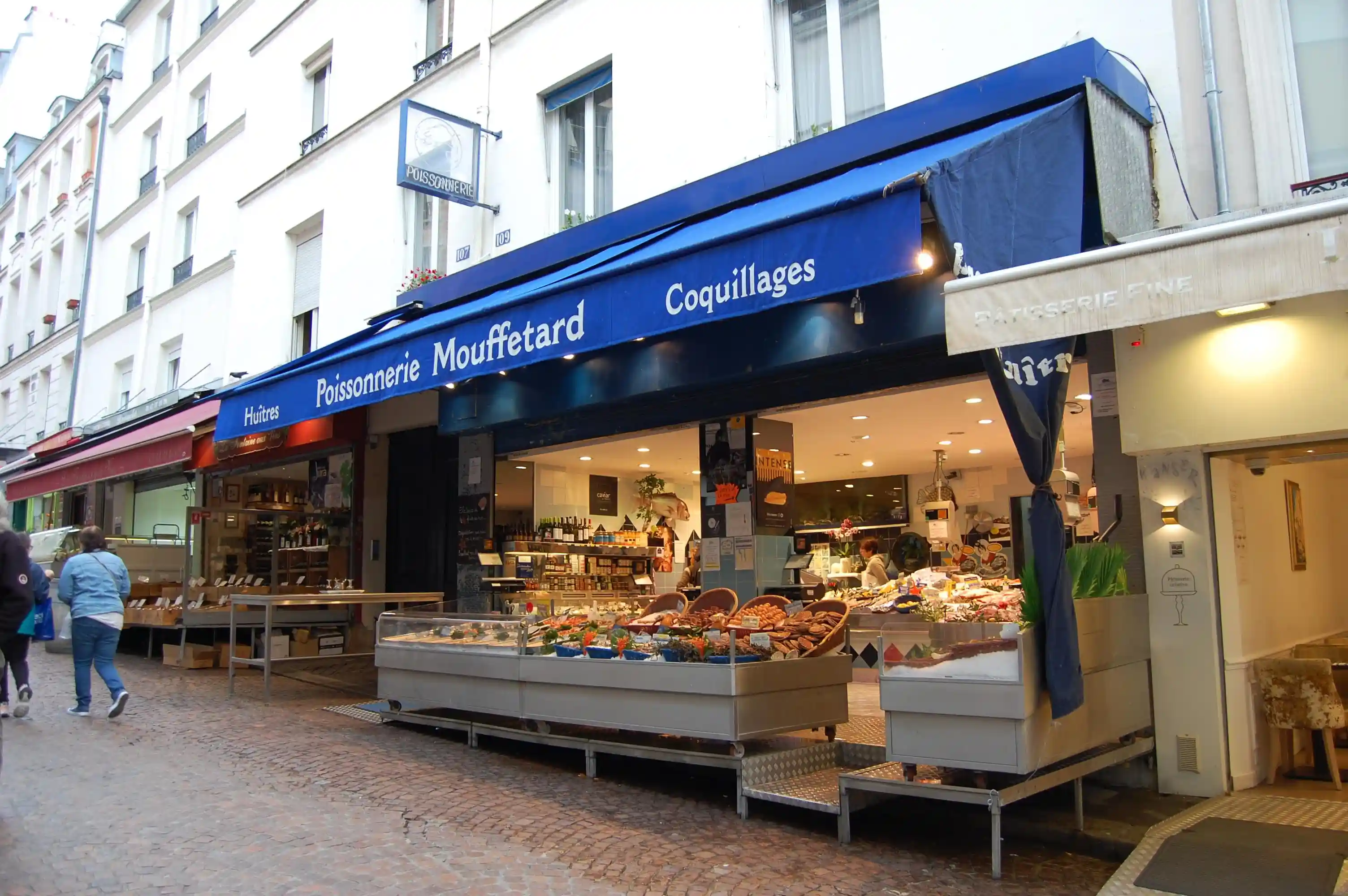 Traditional French poissonnerie (fish shop) on Rue Mouffetard showcasing the authentic market atmosphere and artisanal food specialists of Paris's oldest market street