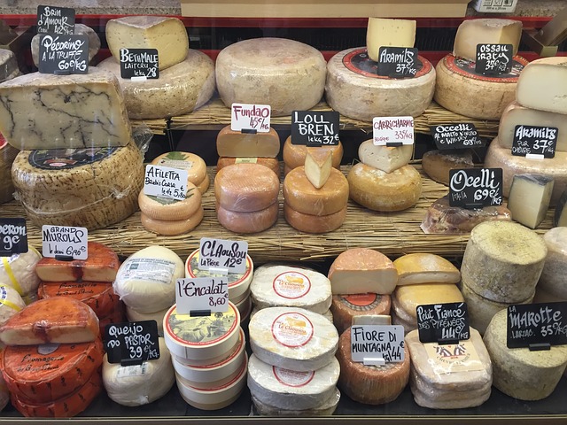 Assortment of French cheeses displayed in a Rue Mouffetard fromagerie window with price labels
